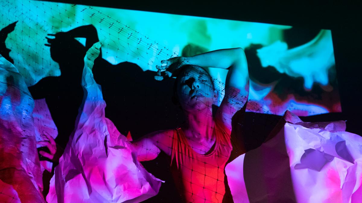 Dancer on a colorful background with paper around them